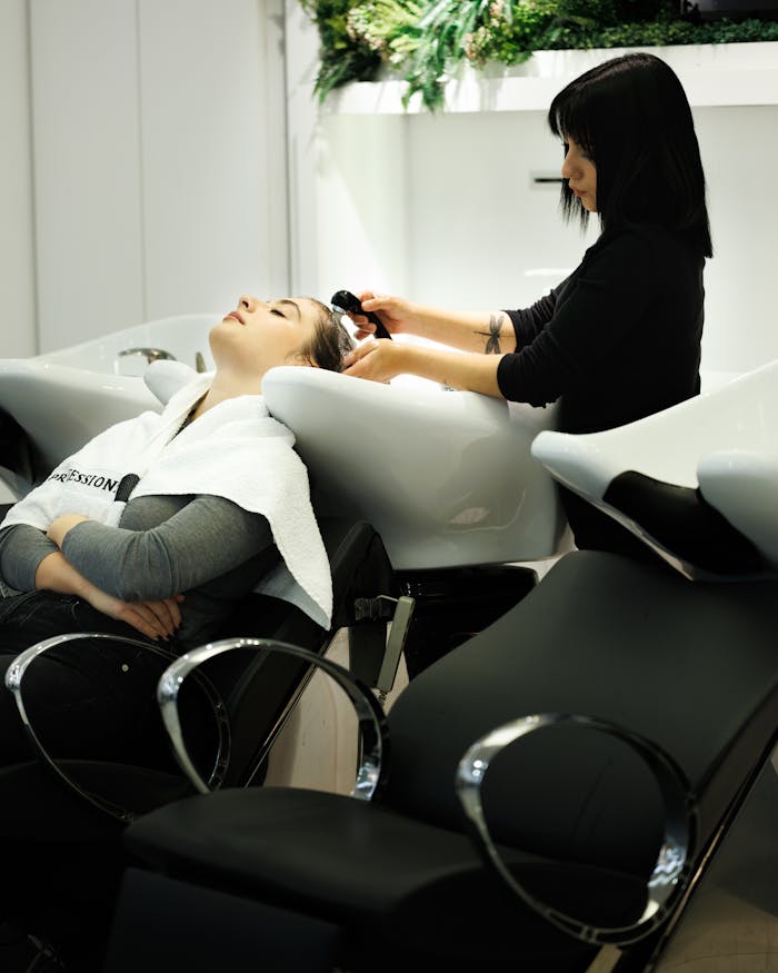 Woman receiving a relaxing hair wash at a salon by a professional hairdresser.